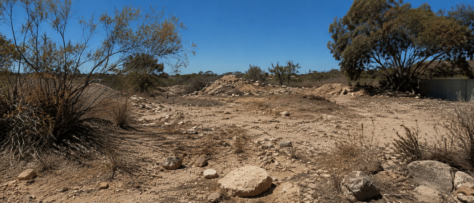 Uncleared block with scrub, rubble and uneven ground